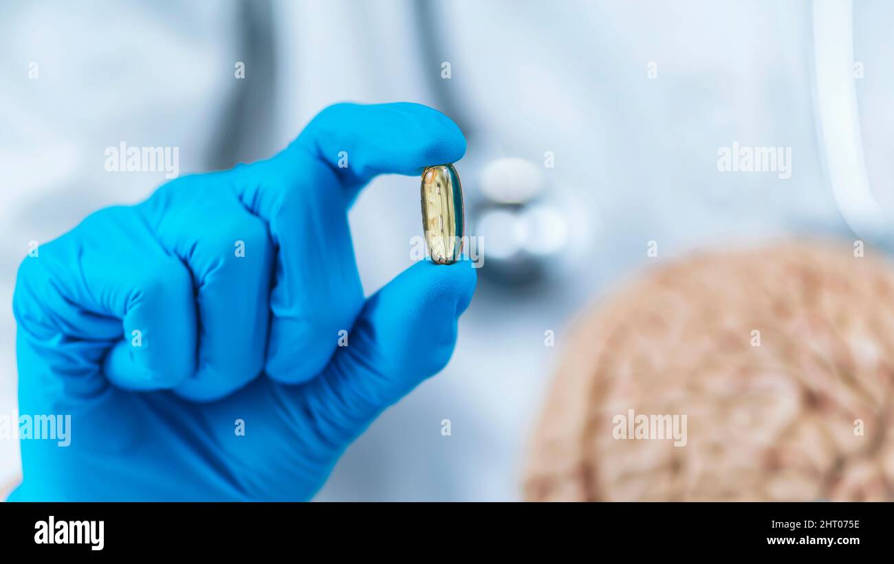 Female doctor holding model of brain and a placebo pill Stock Photo