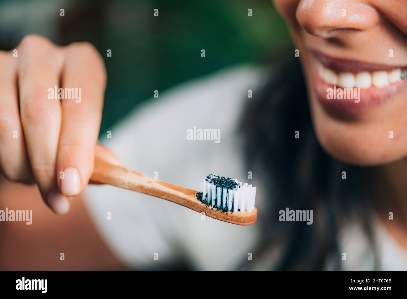Woman brushing teeth with charcoal Stock Photo