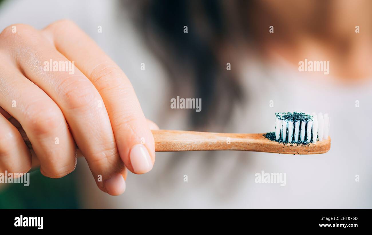 Woman brushing teeth with charcoal Stock Photo Alamy