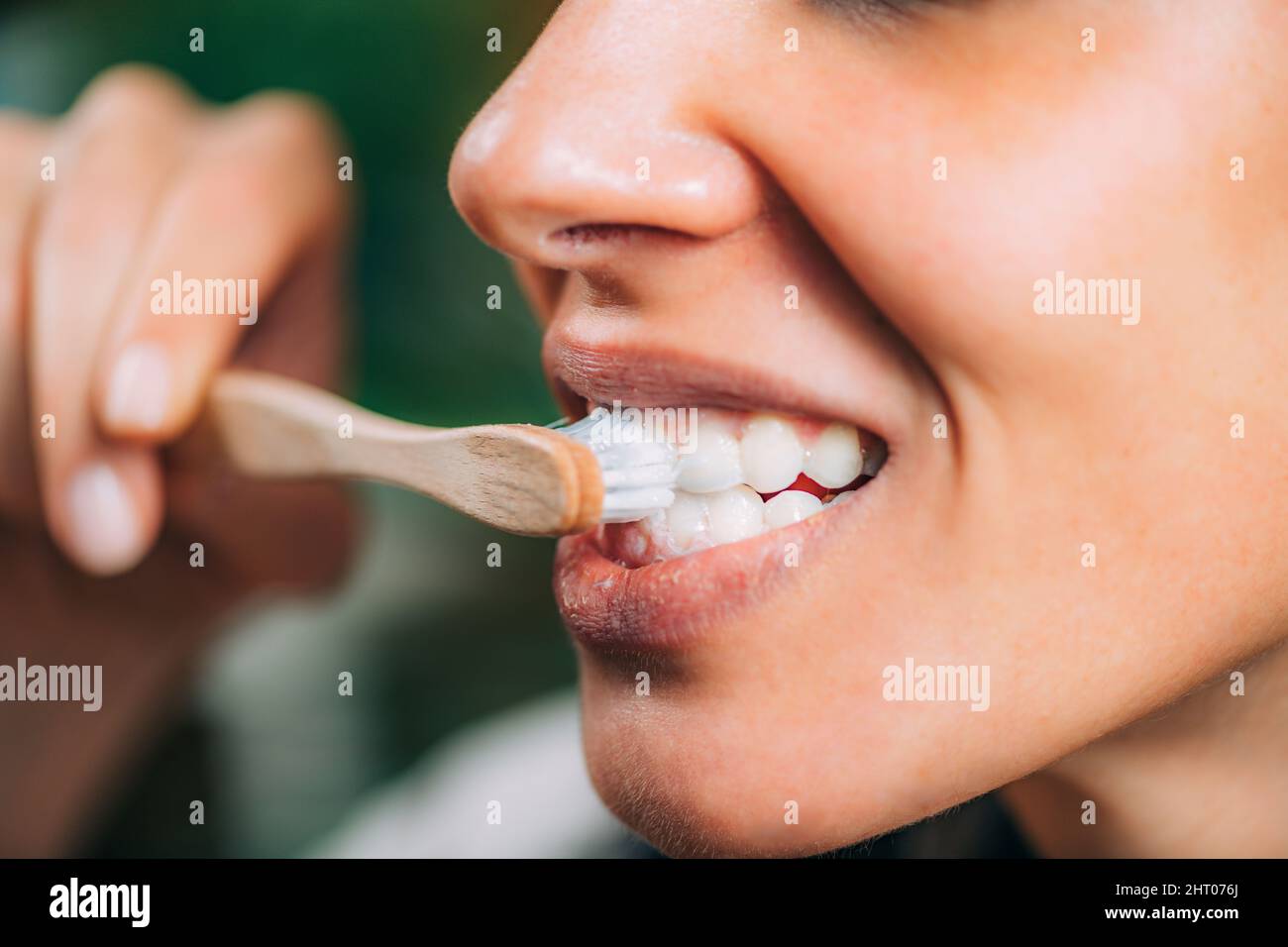 Woman brushing teeth with charcoal toothpaste Stock Photo