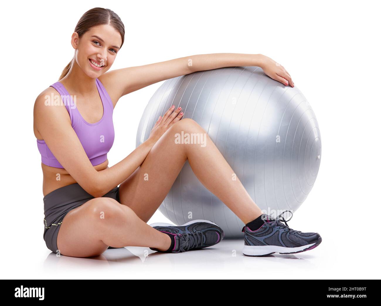 Youre only one workout away from a good mood. Portrait of a young woman sitting next to her fitness ball. Stock Photo