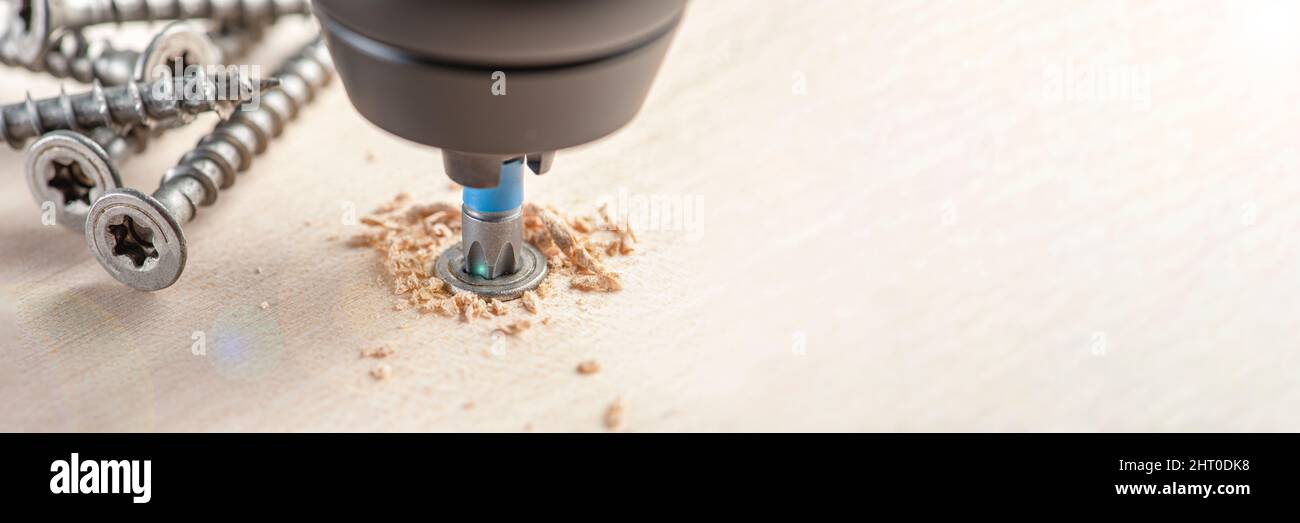 Manufacture of wooden furniture. Driving a screw into a piece of furniture. Assembling wooden furniture close-up Stock Photo