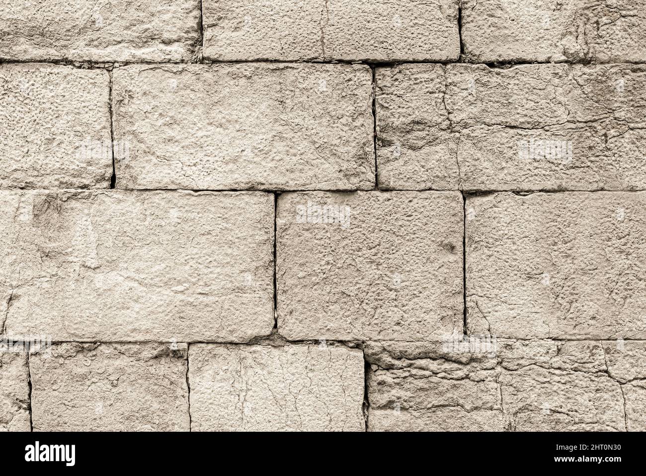 Old gray cracked stone brick wall outside Stock Photo