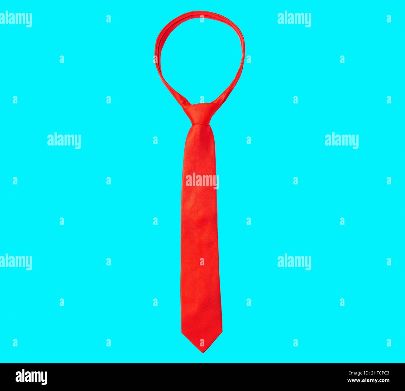 Solid red necktie isolated on blue background. Stock Photo