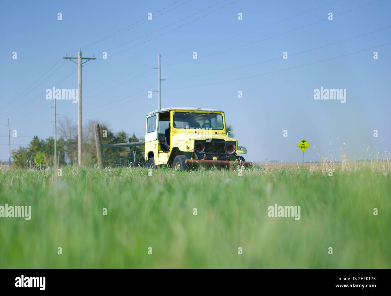 Beautiful shot of a yellow vintage Jeep in a field Stock Photo