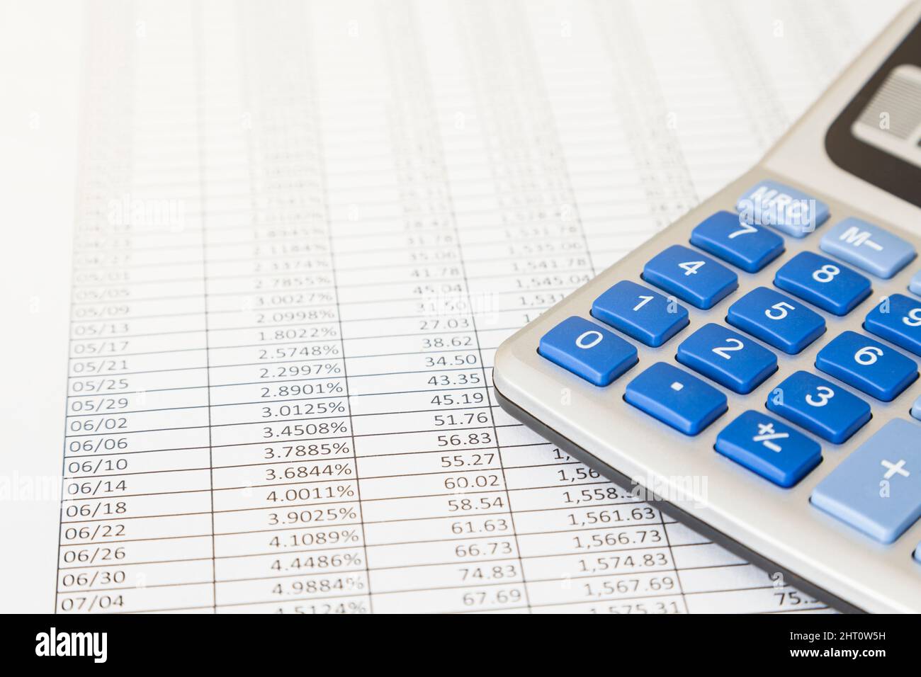 On a printed sheet with a grid full of numbers is a calculator Stock