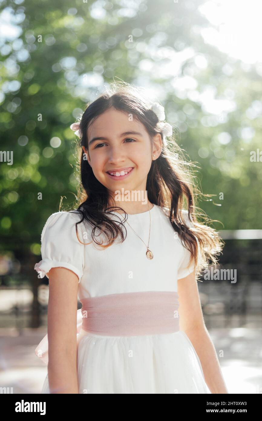 smiling girl in communion dress outdoors Stock Photo