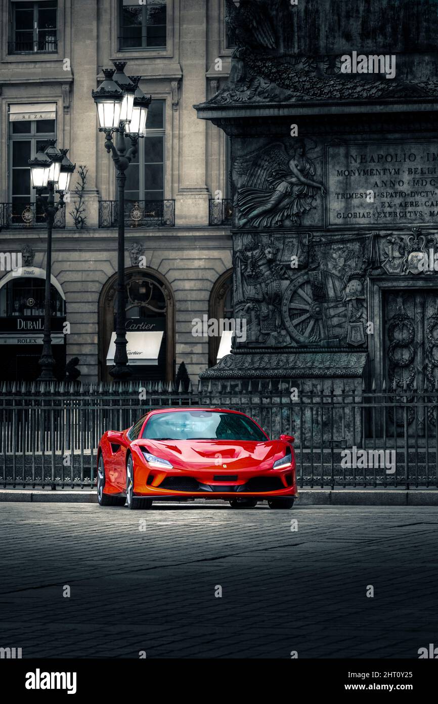 Paris, France - April 29, 2021: Red Ferrari car in front of the Vendome column in Paris Stock Photo