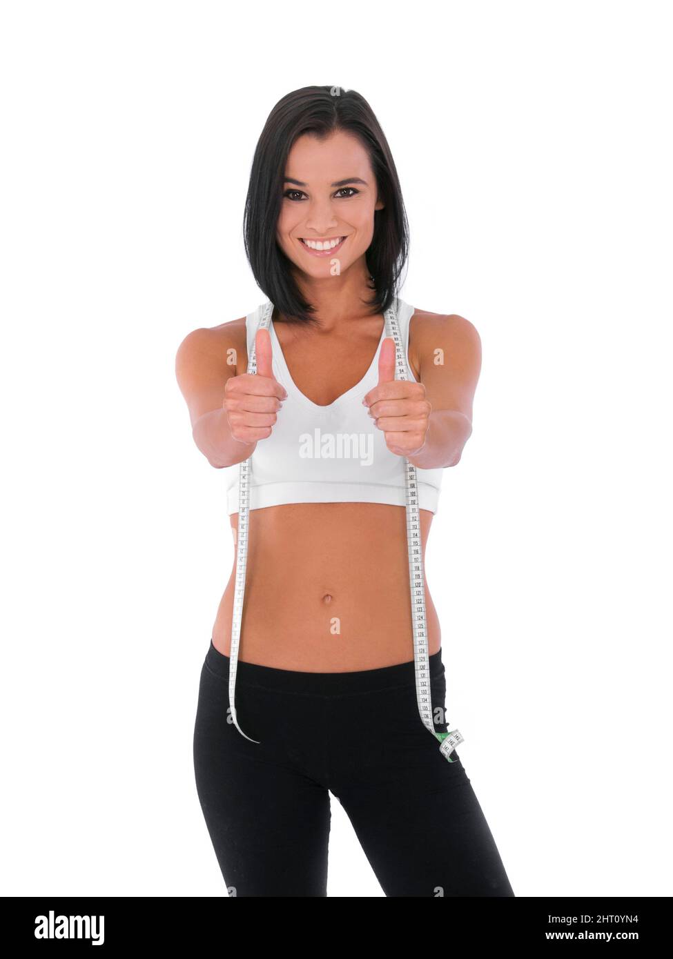 I did it - Fitness Weight loss. A fit young woman giving two thumbs up while isolated on white with a measuring tape around her neck. Stock Photo