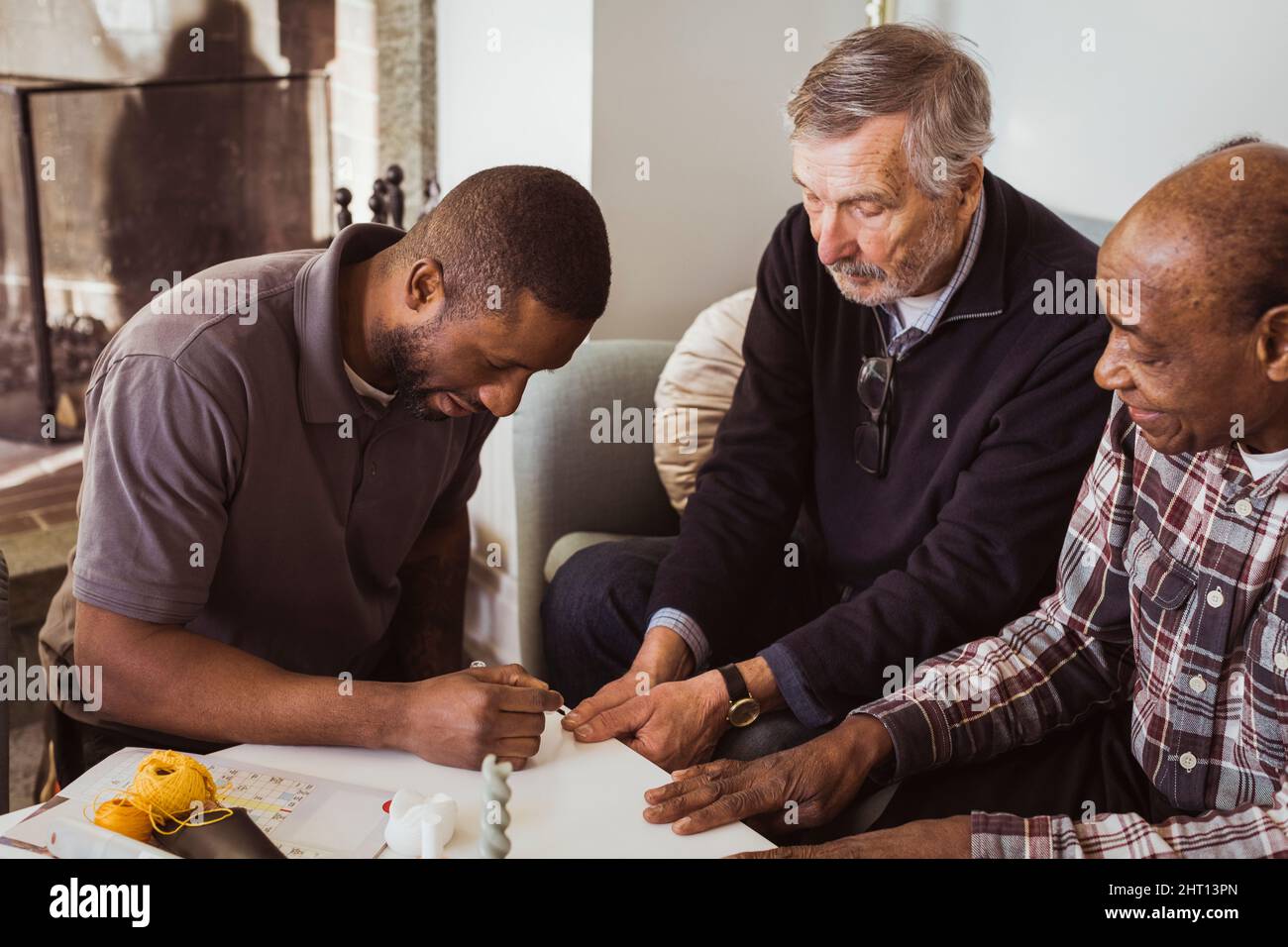 Male healthcare worker applying nail polish to elderly men in nursing