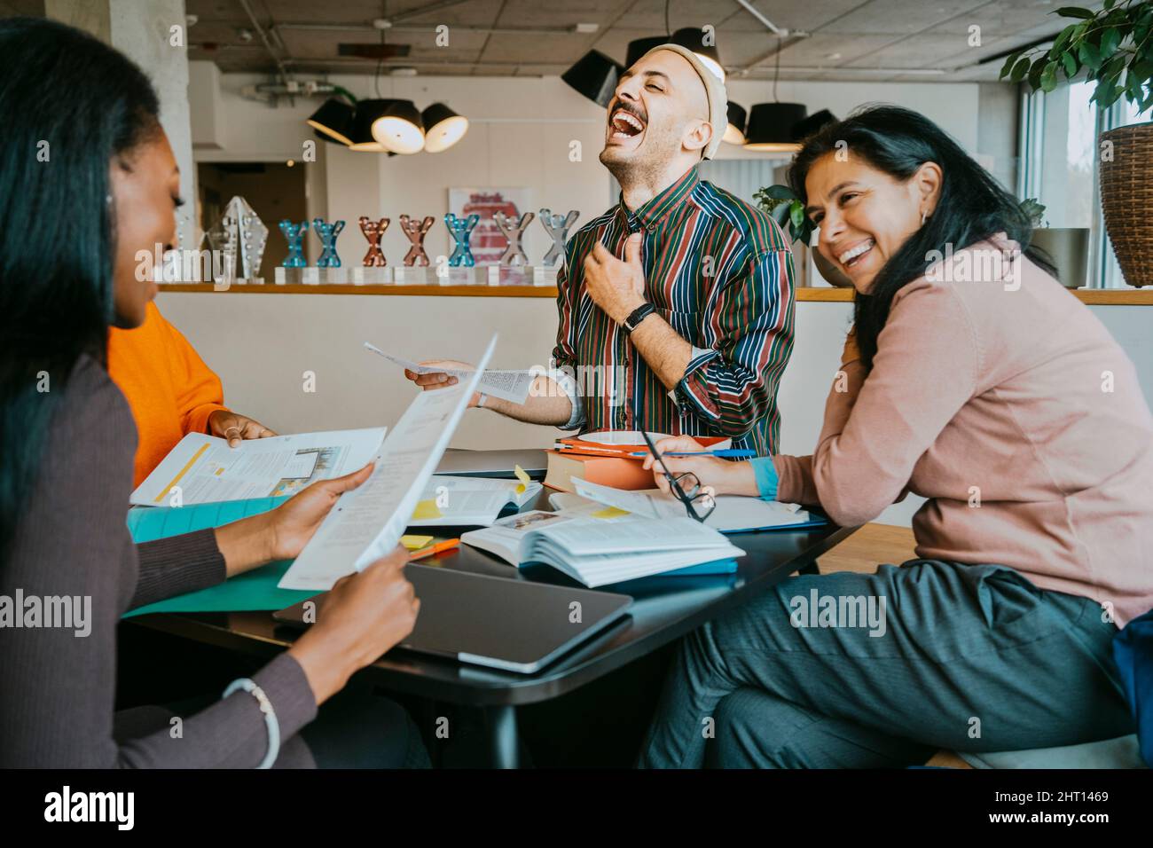 Cheerful university students discussing while enjoying at cafeteria Stock Photo
