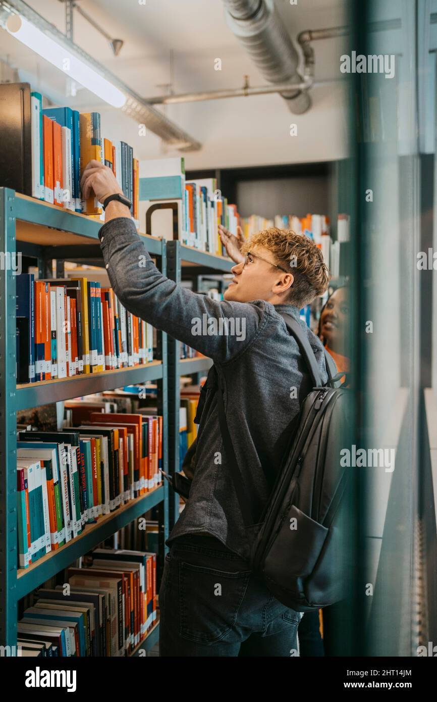 Young students searching book together in library at university Stock Photo