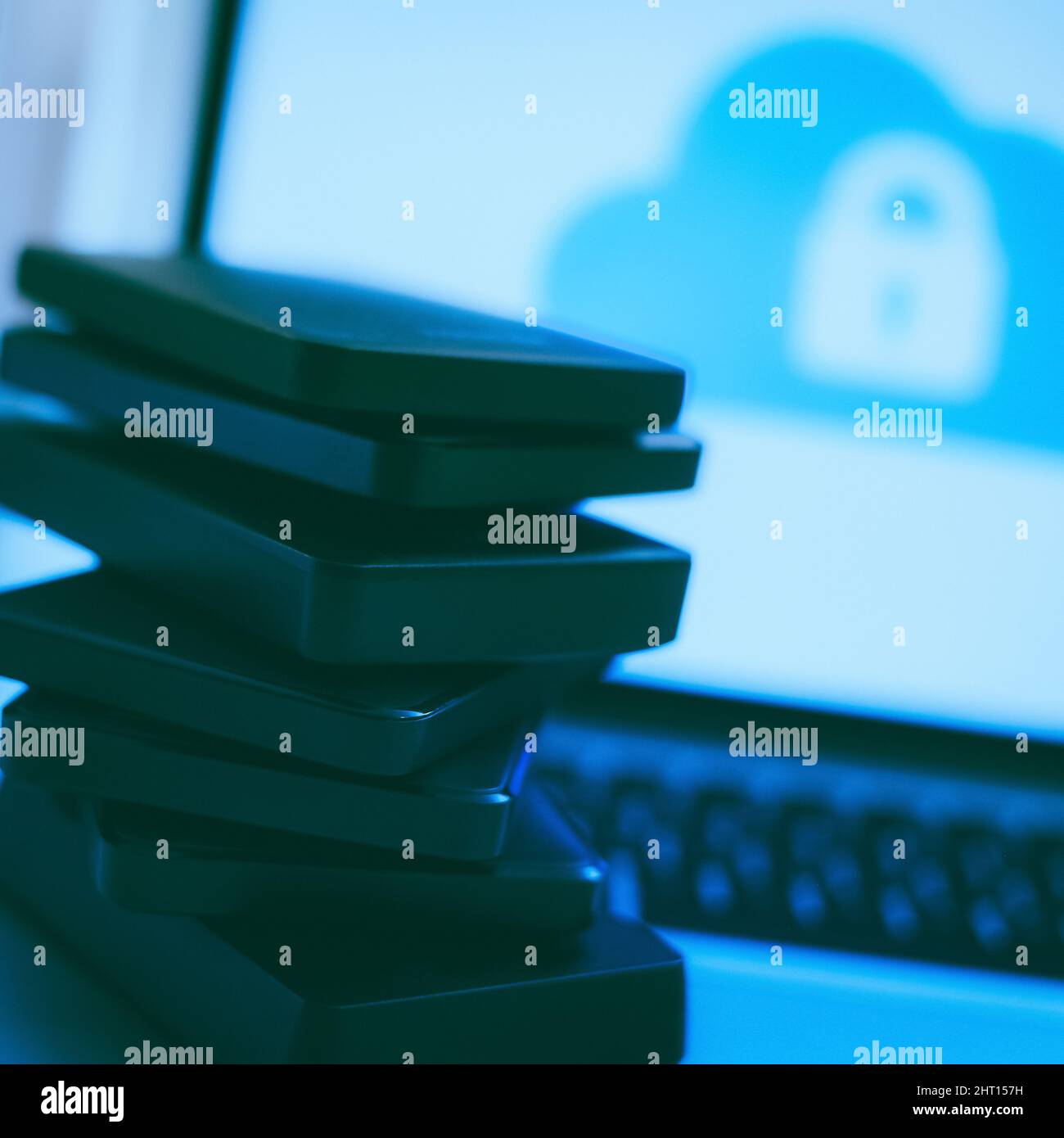 Laptop on the desk with network attached storage. Computer, nas and stack of hard drives on the table. Cloud technology, online disk, remote backup, s Stock Photo