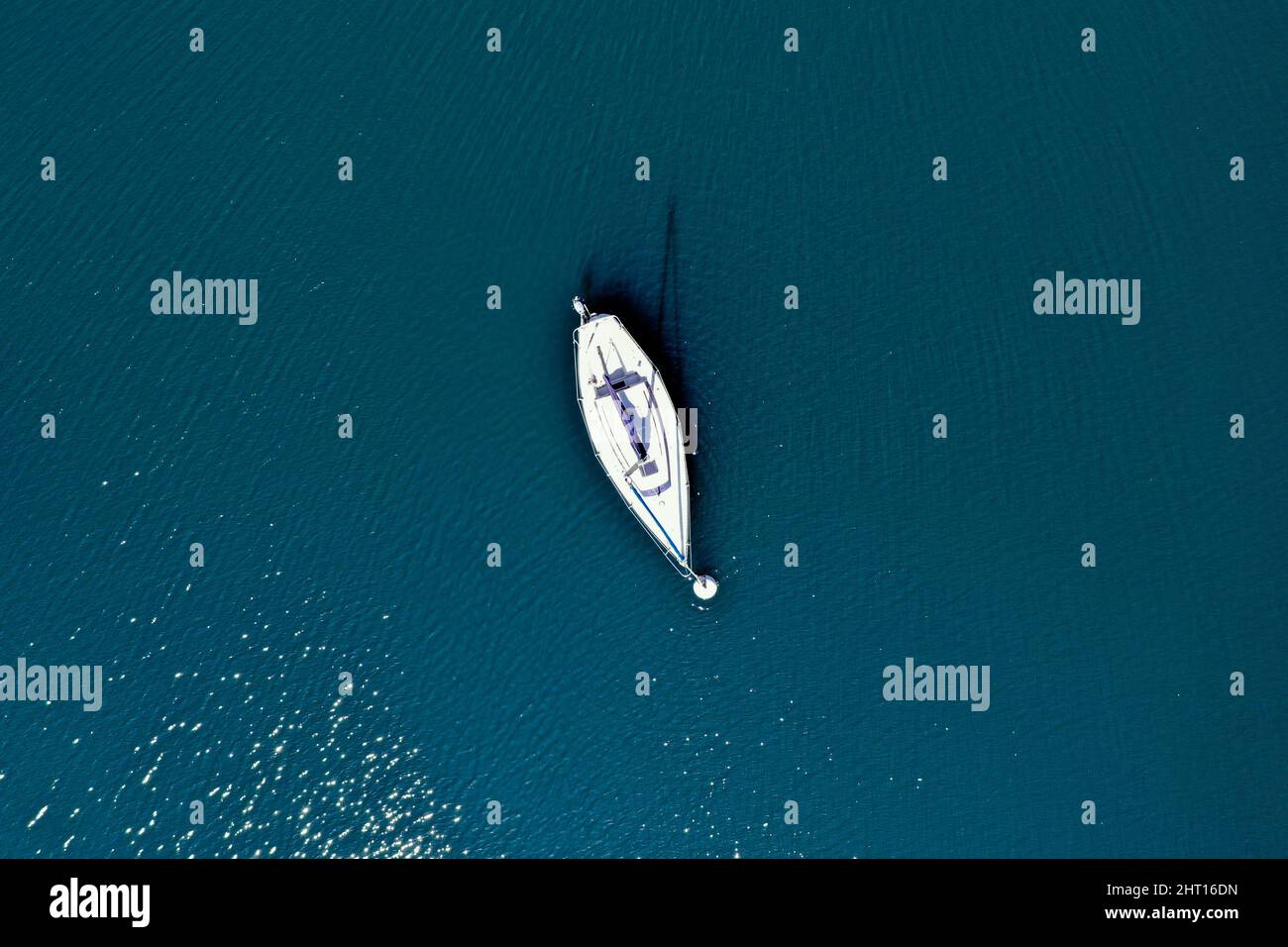 Vertical aerial view of an isolated boat floating on the water of a ...