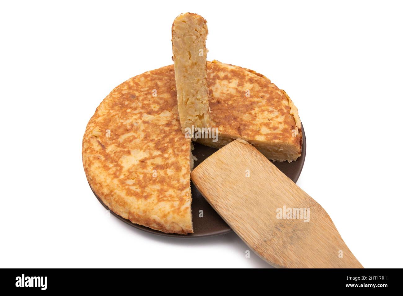 Potato omelette, known as 'Spanish omelette'. With a wooden spoon. Very consumed in Spain. Isolated on white background. Spanish food concept. Stock Photo