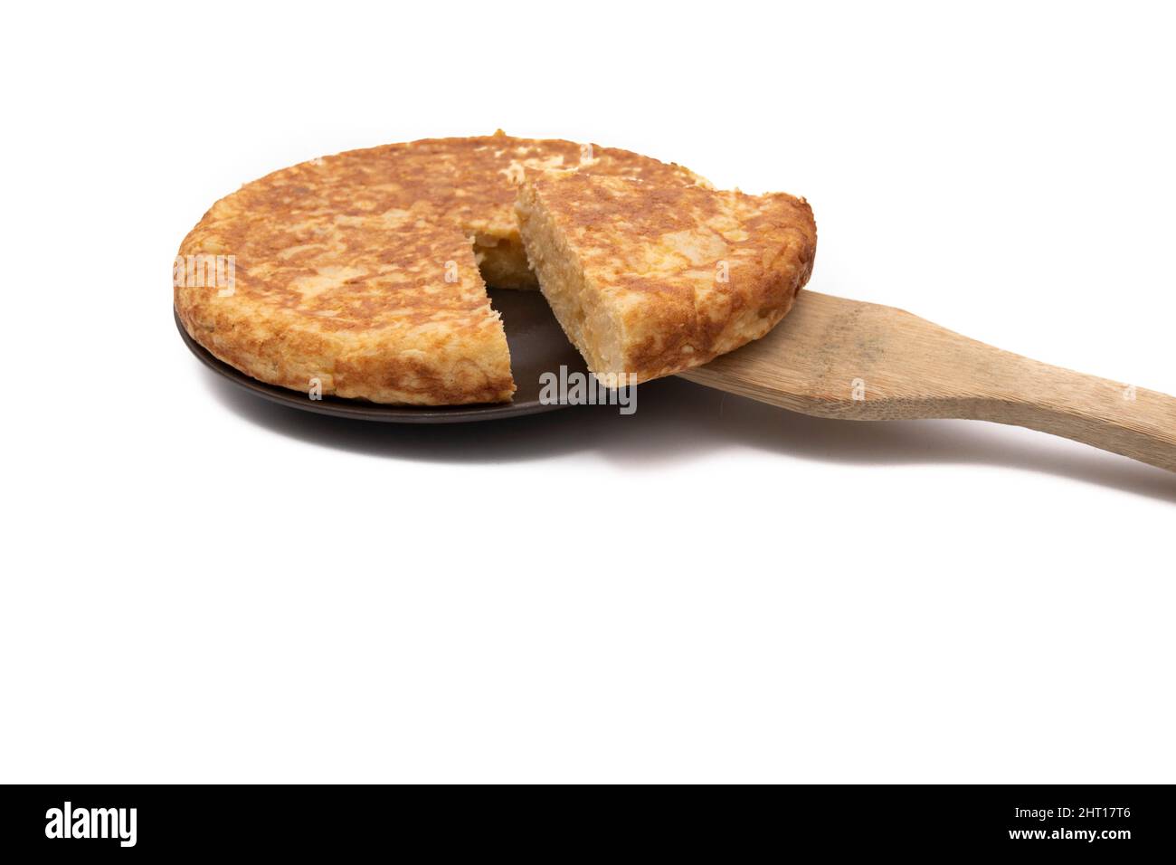 Potato omelette, known as 'Spanish omelette'. With a wooden spoon. Very consumed in Spain. Isolated on white background. Spanish food concept. Stock Photo