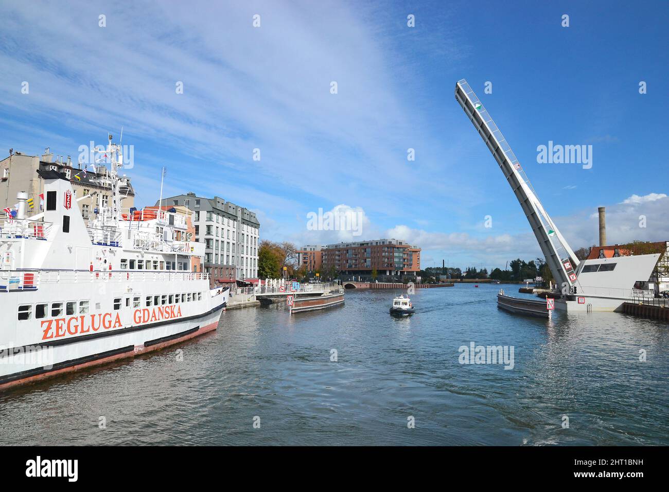 Gdansk, Poland - September 28, 2018: View of lifting bridge in elevated condition, passing boat on Motlawa river in Gdansk, Poland. Stock Photo