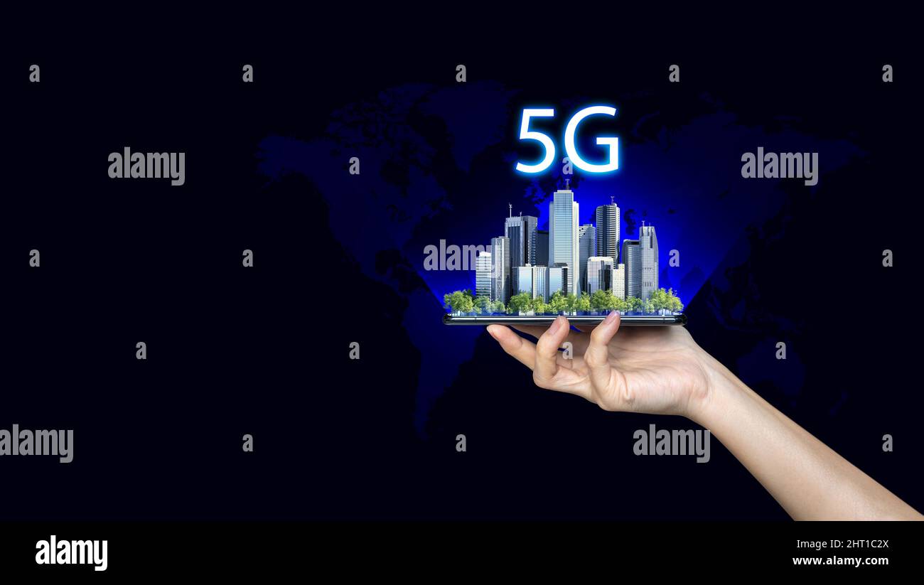 5G internet connection digital tablet concept. Businessman hold mobile with 5G broadband cellular network around city. Stock Photo