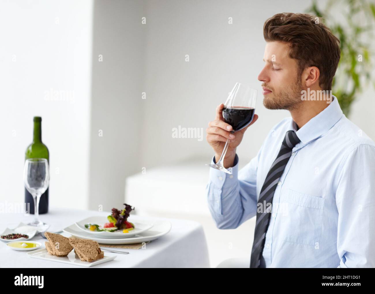 This smells like an excellent bouquet. Attractive young man appreciating the scent of a good wine in a restaurant. Stock Photo