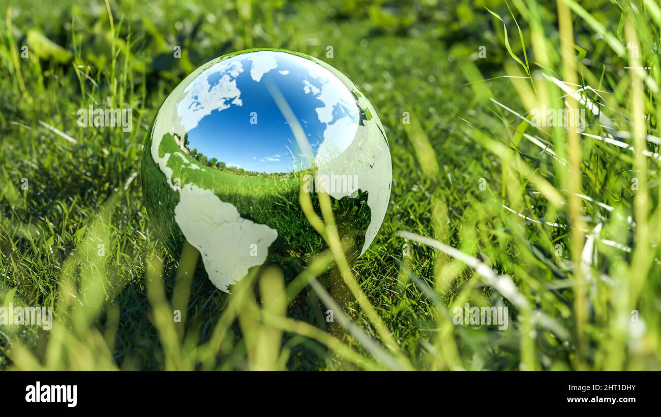 Close up view of planet earth globe crystal ball on a green grass field. Environmental protection, ecology and crystal ball of the world. Concept of e Stock Photo