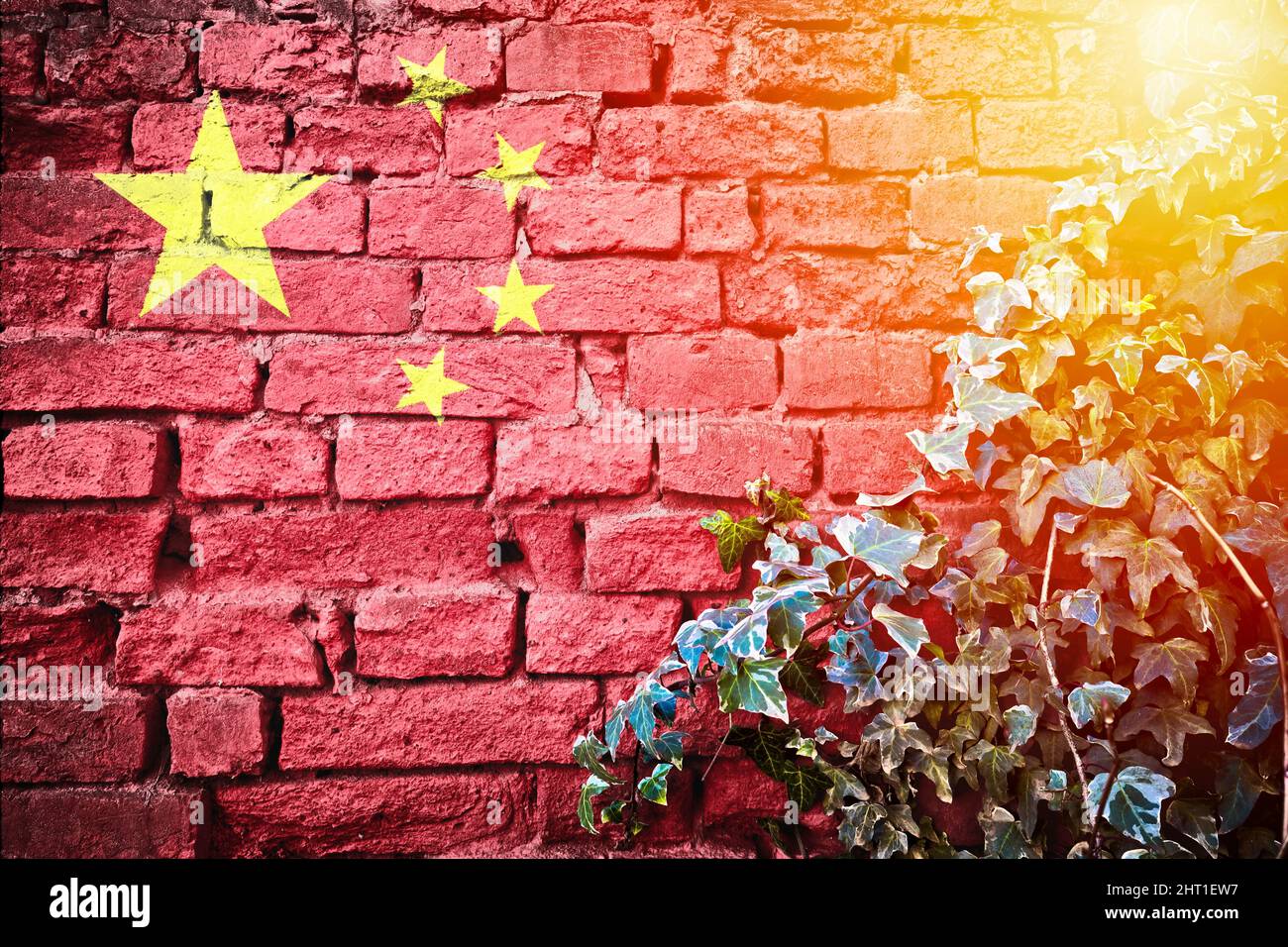 China grunge flag on brick wall with ivy plant sun haze view, country symbol concept Stock Photo