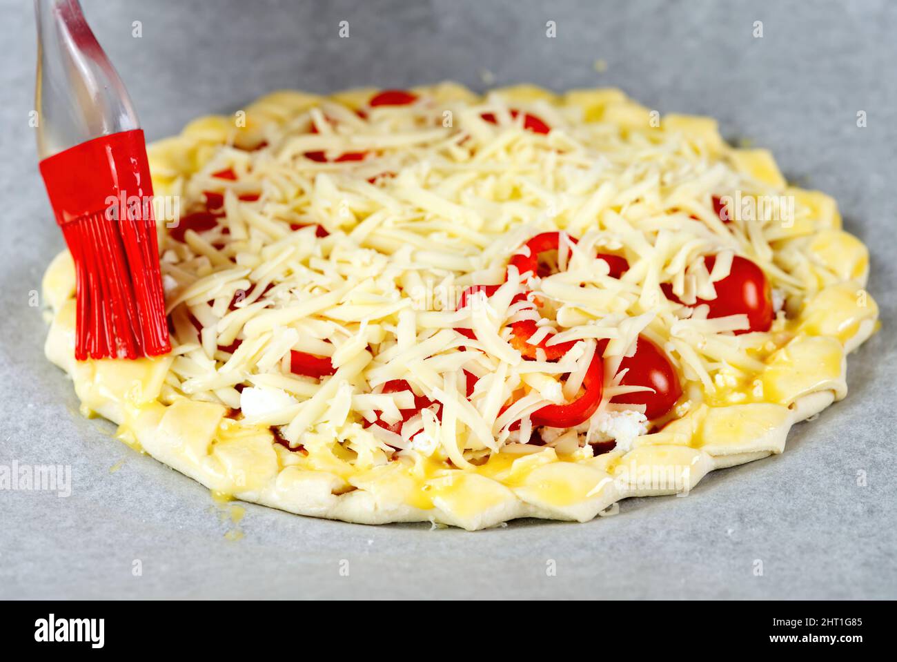 Pizza making process. Top view of pizza dough base with a braided pie