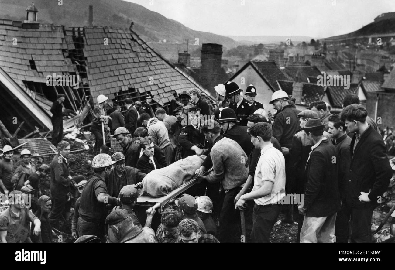 Aberfan 21st October 1966 For a moment the digging stops as another body is brought from the shattered Pantglas Junior School following the catastrophic collapse of a colliery spoil tip in the Welsh village of Aberfan, killing 116 children and 28 adultsThe events of Friday, 21 October 1966 Tip no. 7, which was 500 feet above the village of Aberfan, near Merthyr Tydfil, started to slide at 9.15 am. It was the last day before half-term at the Pantglas schools below.  It first hit a farm, killing everybody in it. Then it engulfed Pantglas Junior School, killing 109 children and five teachers. Onl Stock Photo