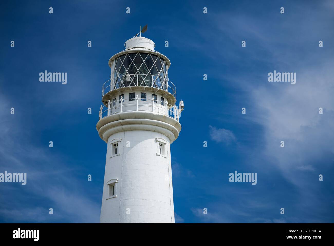 White lighthouse against the blue sky. Stock Photo