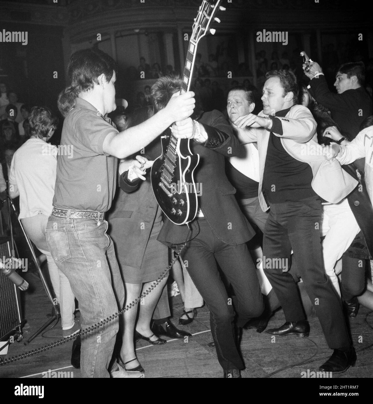 Rolling Stones at Royal Albert Hall, London. 23 September 1966 during their tour with Ike & Tina Turner. Ian 'Stu' Stewart takes Keith's Richards's guitar Stock Photo