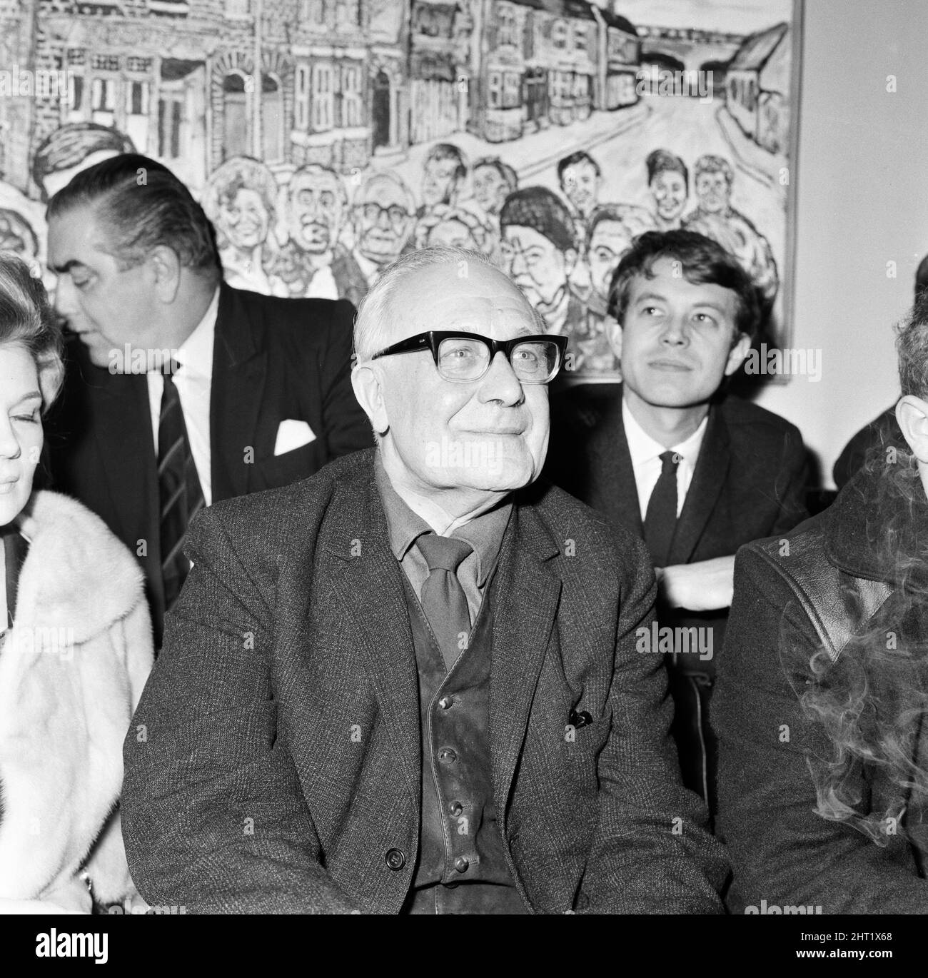 Artist John Bratby, the famous mural painter, has completed a painting on which 15 characters of Coronation Street figure. The picture was on view at the Whitworth Art Gallery, Manchester, at which several cast members attended. Arthur Leslie (Publican Jack Walker) has no criticisms of the painting. 9th February 1966. Stock Photo