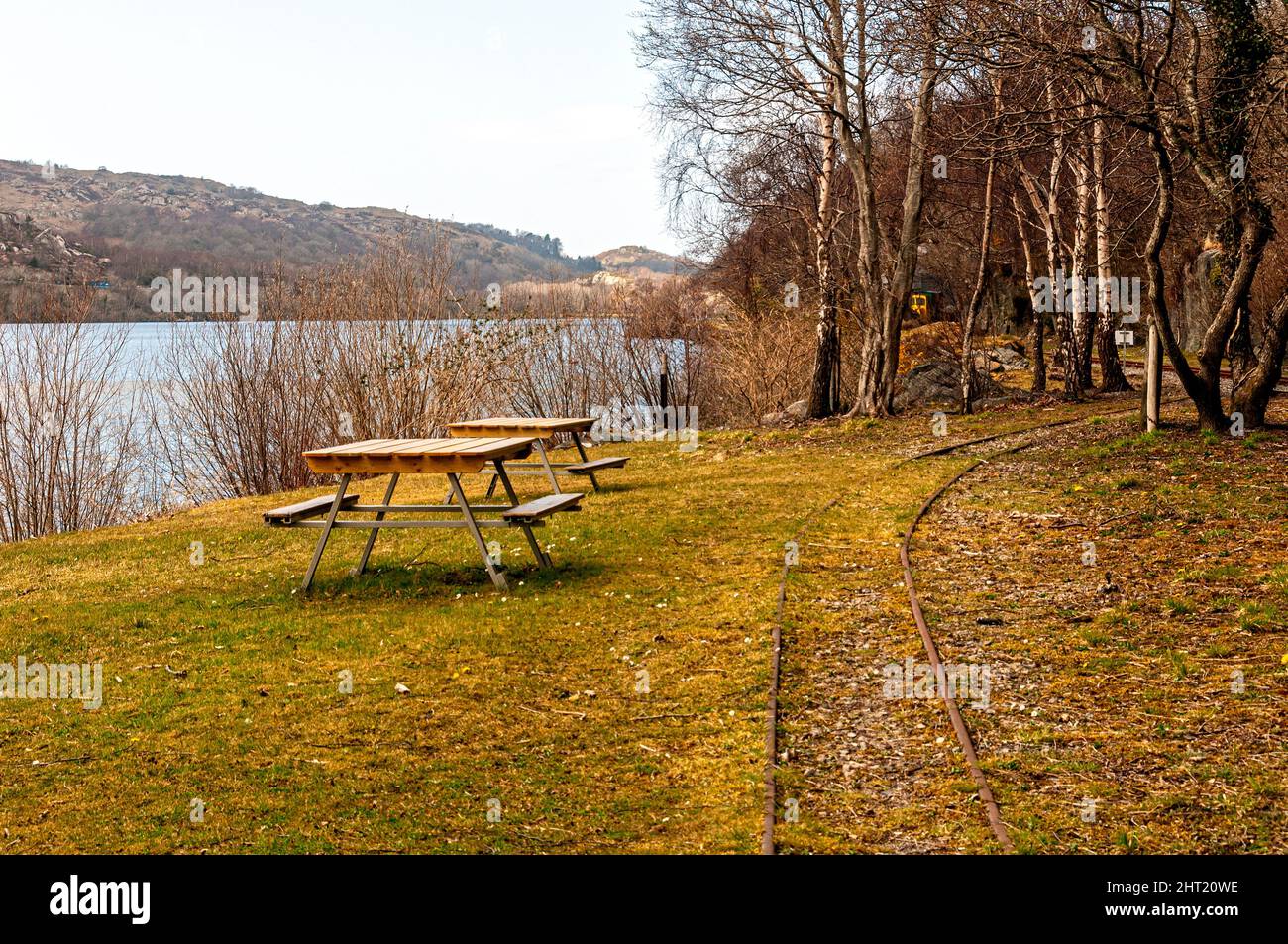 Lakeside benches at Cei Llydan station where the Llanberis Lake Railway makes a short stop provides a tranquil picnic spot at the side of Llyn Padarn Stock Photo