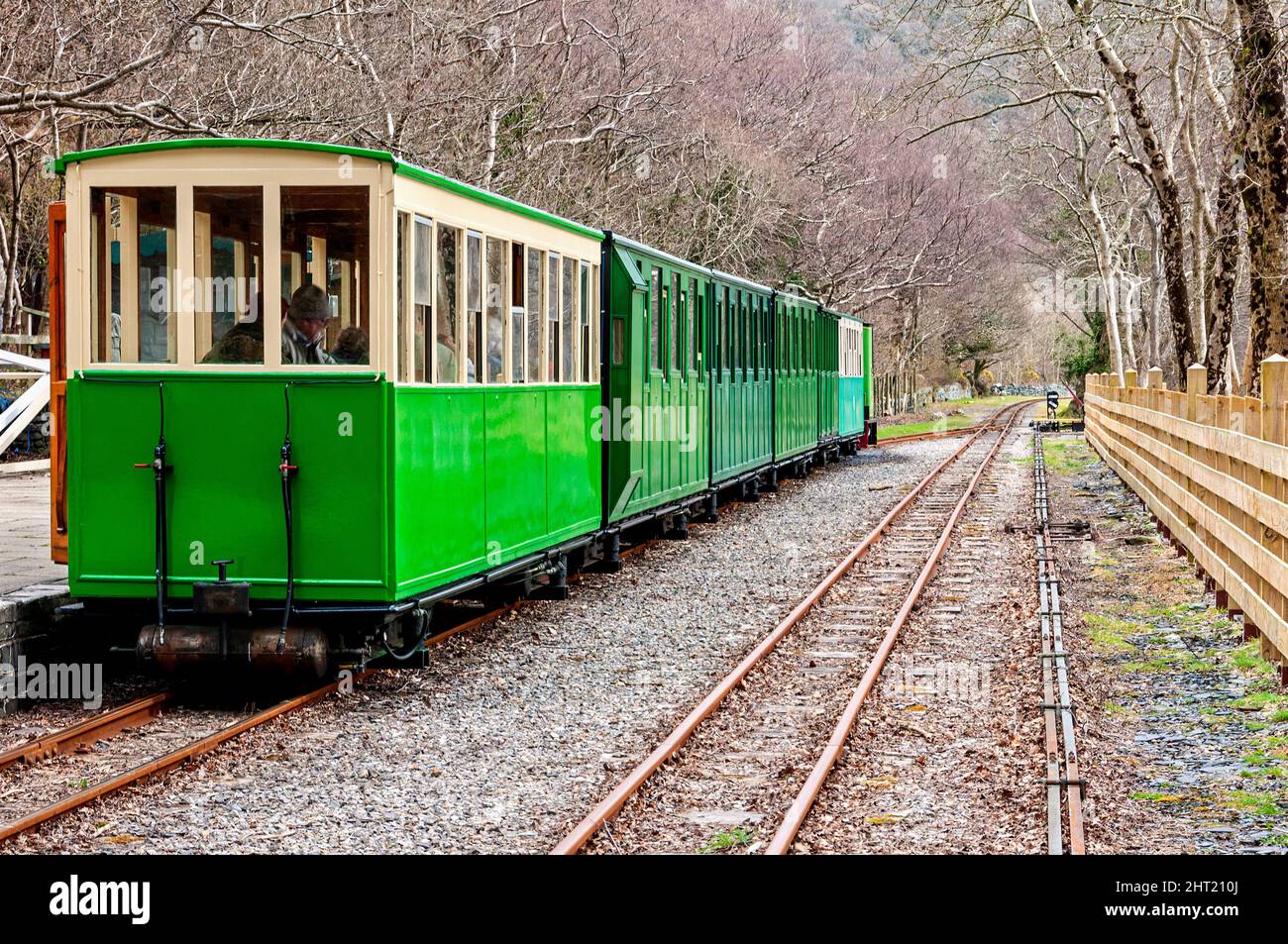 Passenger carrying railway carriages behind a locomotive stopped at the platform of Cei Llydan station, on the Llanberis Lake Railway Stock Photo