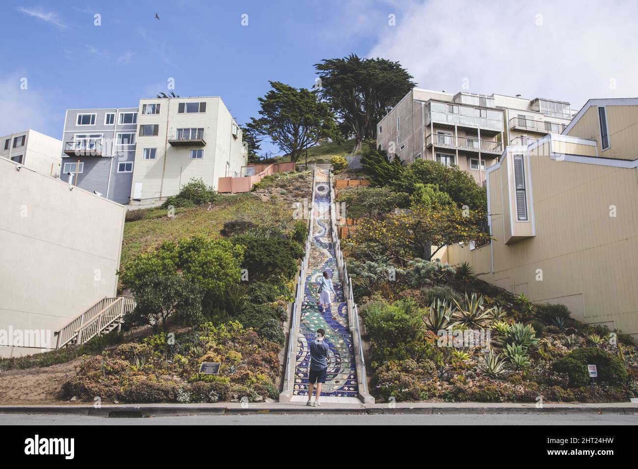 People climbing up the 16th Avenue Tiled Steps surrounded by buildings in San Francisco
