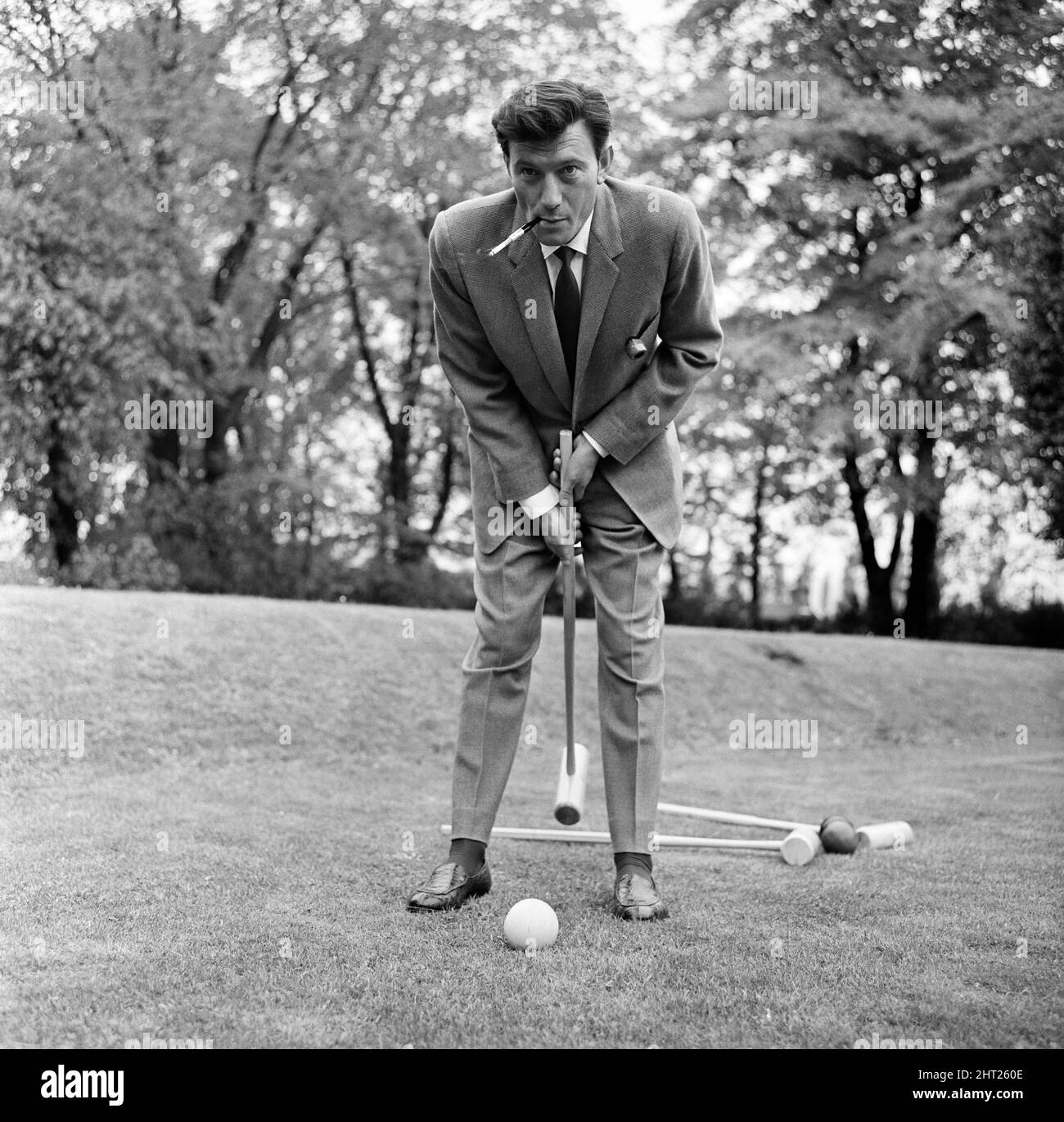 Laurence Harvey has a quick game of croquet on the lawn of the house in Priesthorpe Lane, in Bingley, Yorkshire, where filming of 'Life at the Top' takes place today. 24th May 1965. Stock Photo