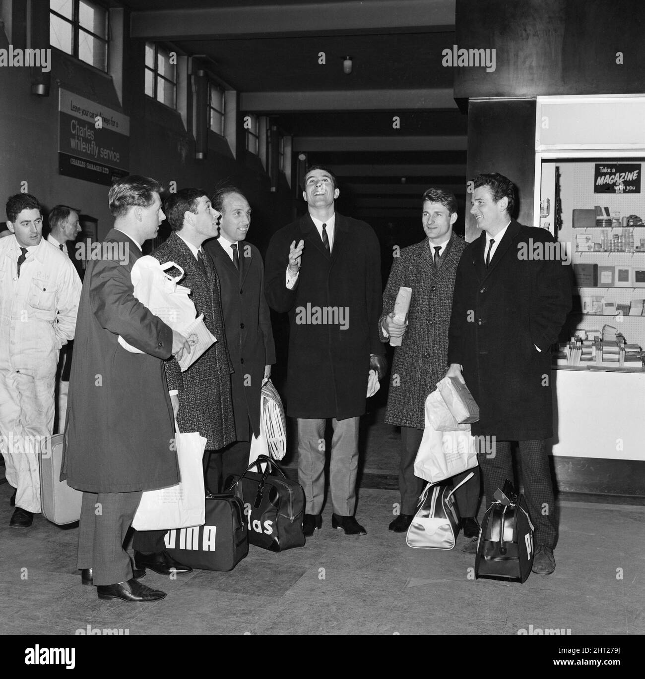 Liverpool captain Ron Yeats smiles as he flicks a coin into the air watched by fellow players following their arrival at Speke Airport from Cologne.From left to right: Gordon Milne, Ian Callaghan, Ronnie Moran, Yeats, Roger Hunt and ommy Lawrence. 25th March 1965. Stock Photo
