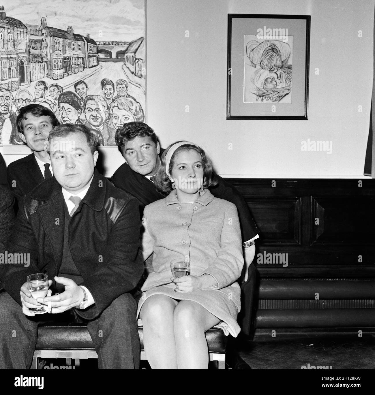 Artist John Bratby, the famous mural painter, has completed a painting on which 15 characters of Coronation Street figure. The picture was on view at the Whitworth Art Gallery, Manchester, at which several cast members attended. Anne Reid (Valerie Barlow) and Peter Adamson (Len Fairclough) at the viewing. 9th February 1966. Stock Photo