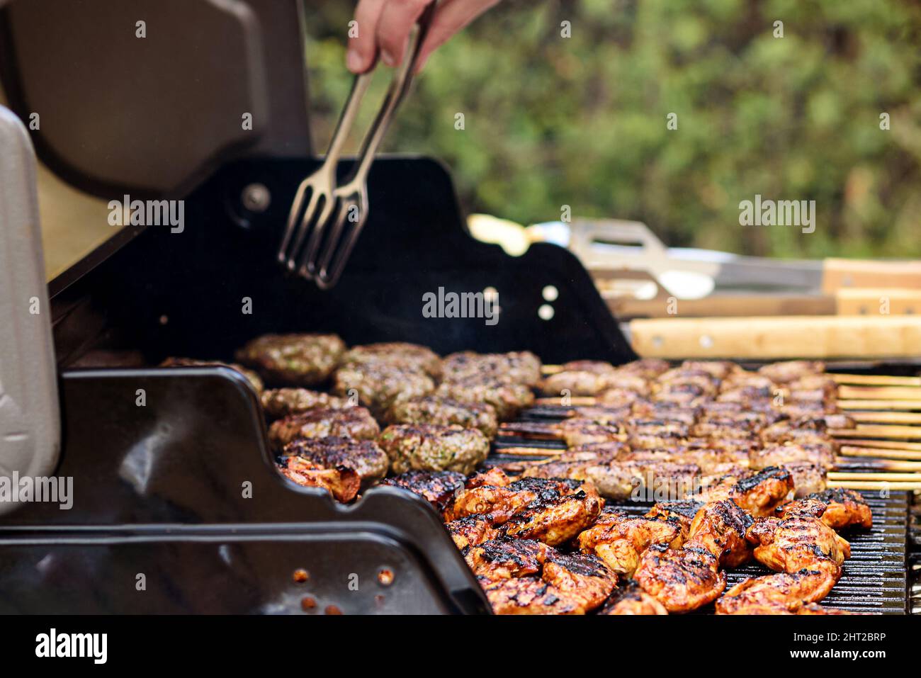 Family having a barbecue party in their garden in summer. Preparation