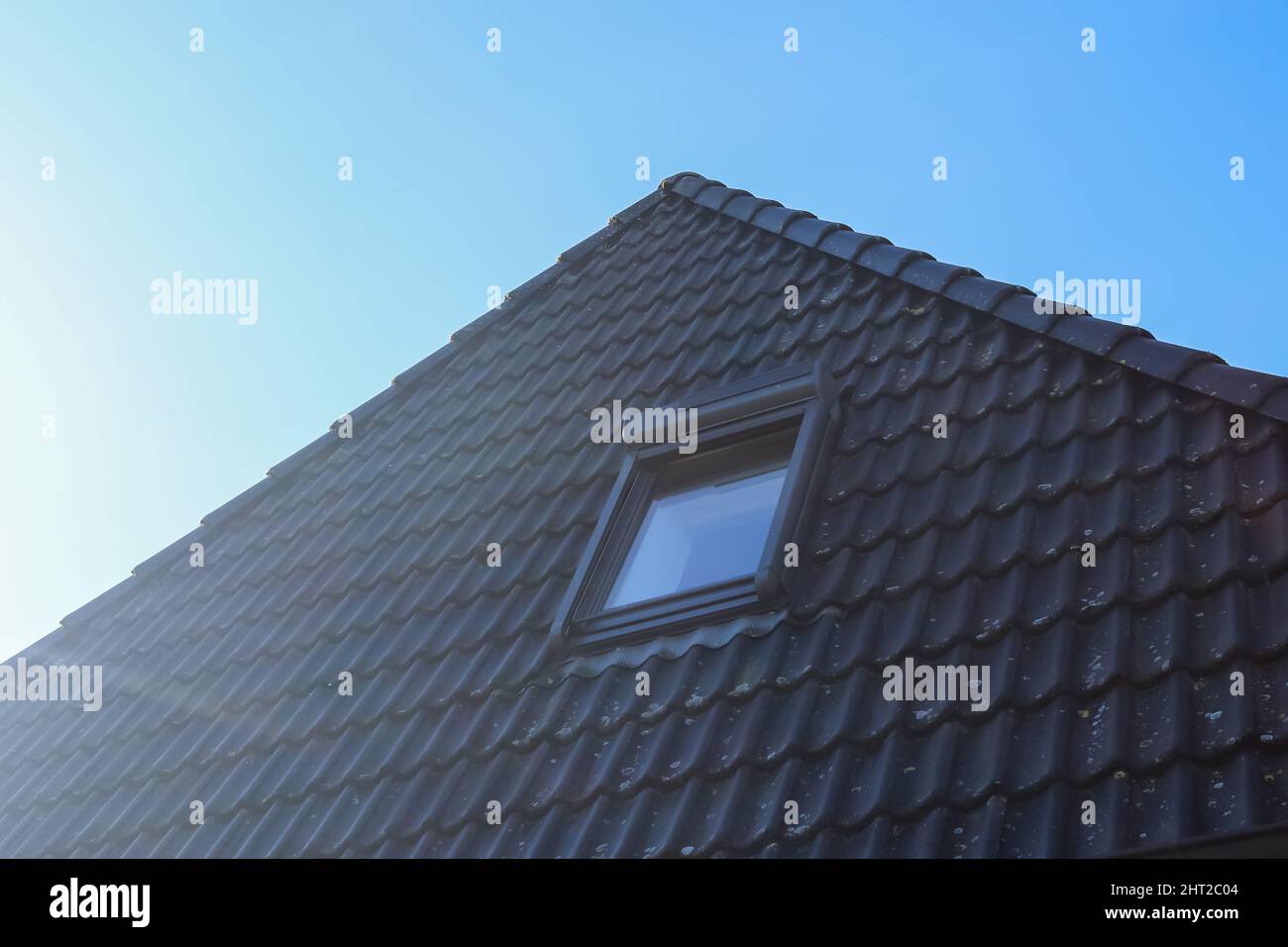 Open roof window in velux style with black roof tiles Stock Photo Alamy