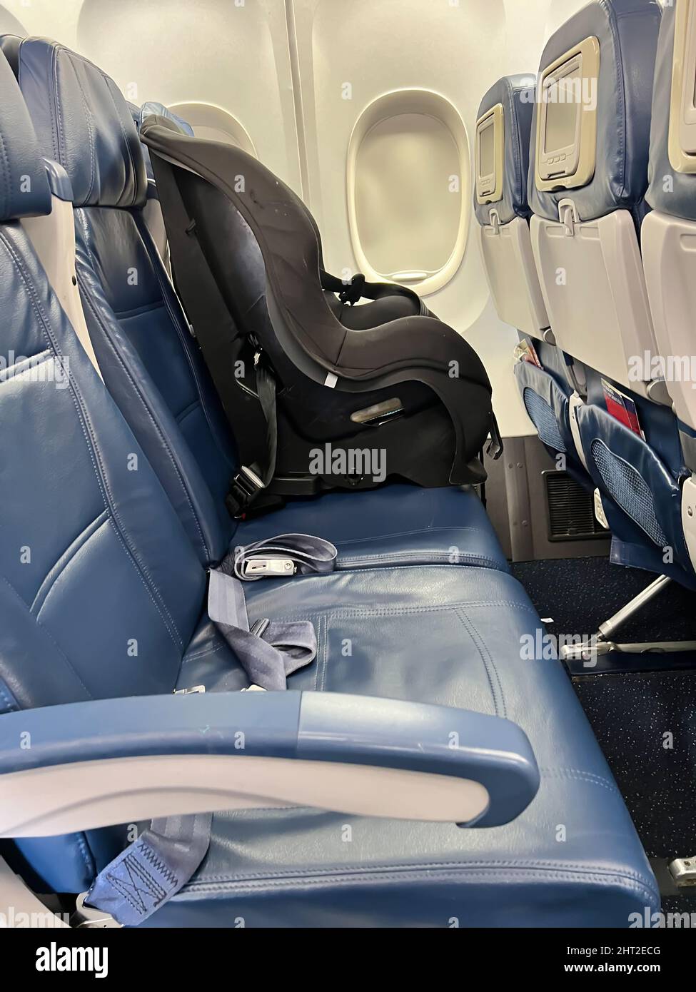 Child car seat placed next to a window on an airplane Stock Photo Alamy