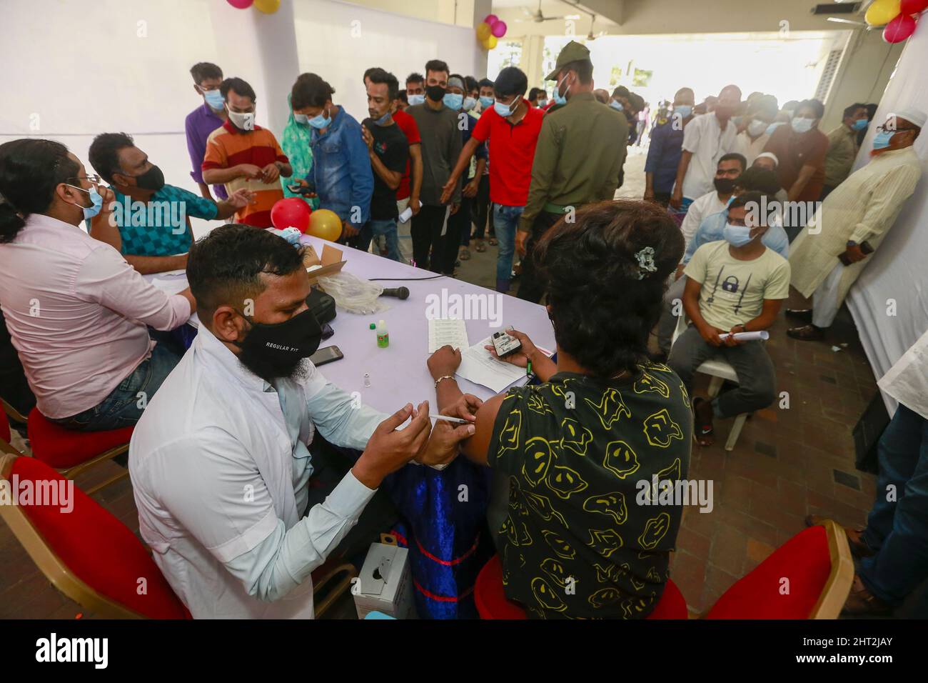 Dhaka, Bangladesh. 26th Feb, 2022. Bangladeshi people receives a dose of the coronavirus vaccine at an inoculation center as the government takes its vaccination drive to the grassroots, in Dhaka, Bangladesh, February 26, 2022. Some vaccination centers were overwhelmed as thousands turned up to try to get their first dose of the coronavirus vaccine on the inoculation of 10 million people in a single-day nationwide drive. (Credit Image: © Suvra Kanti Das/ZUMA Press Wire) Stock Photo