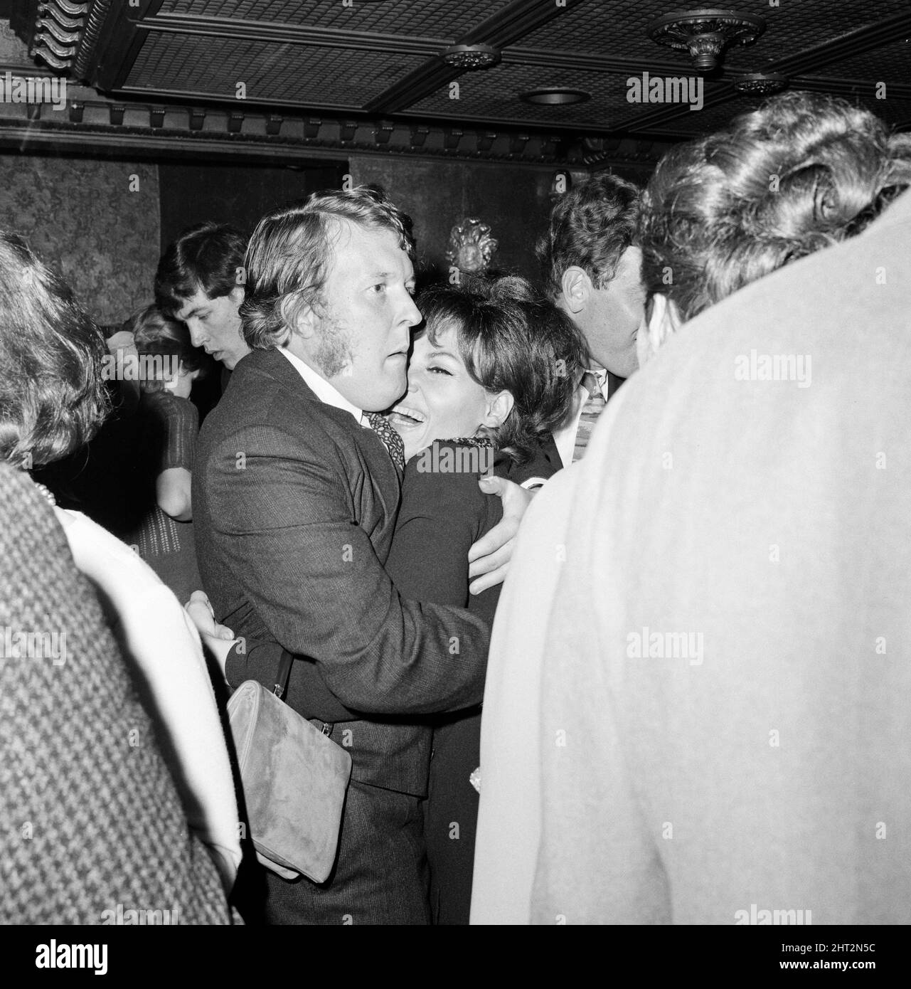 Ned Sherrin, producer of the BBC satire programme BBC 3, which had its last show on Saturday night gave a party to the cast at the Pickwick Club. Pictured, holding singer Cleo Laine with a tight embrace and a stiff upper lip look and wearing Victoria side whiskers is William Rushton. 17th April 1966. Stock Photo