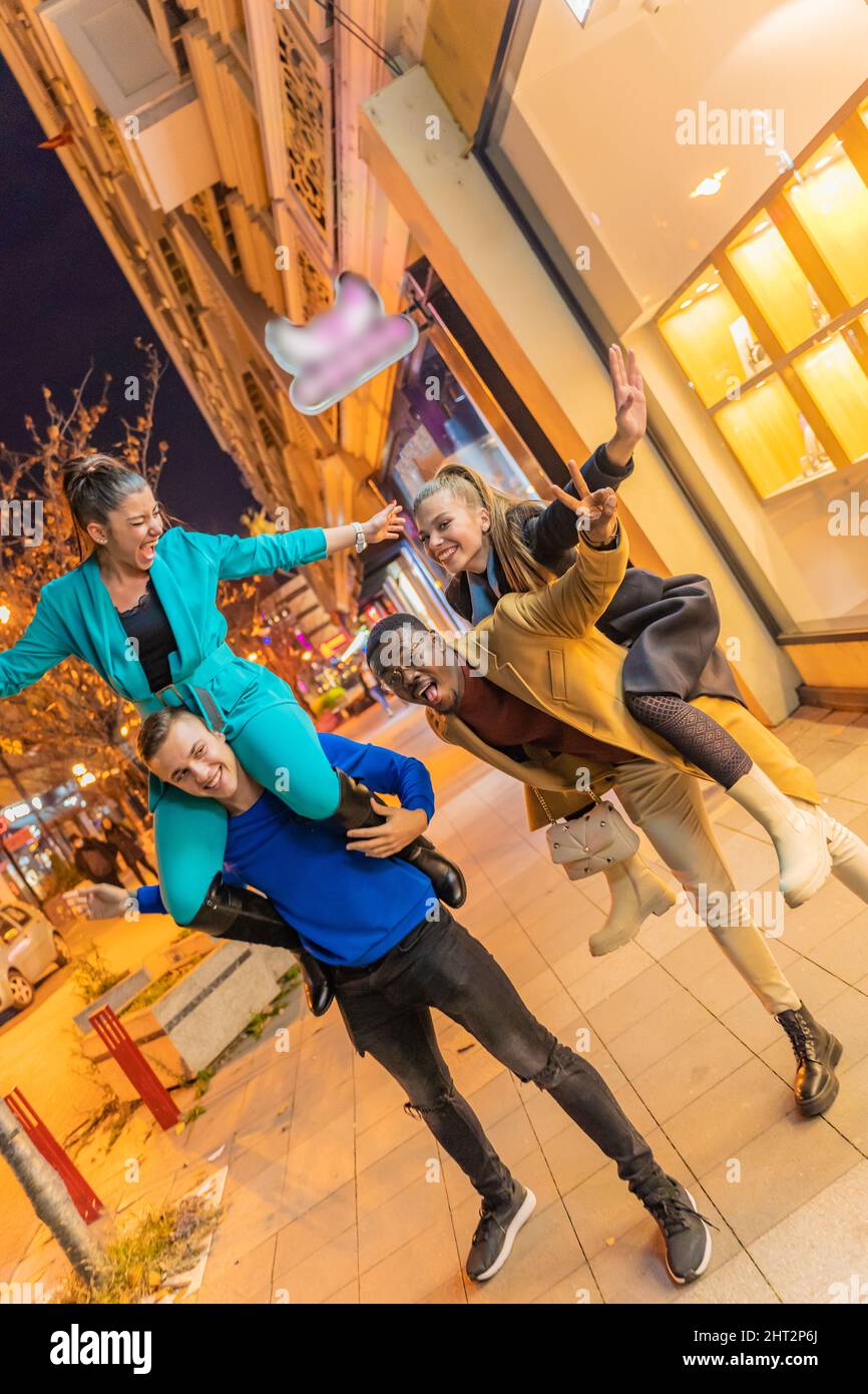 Two multiracial couples are doing a piggyback ride together Stock Photo ...
