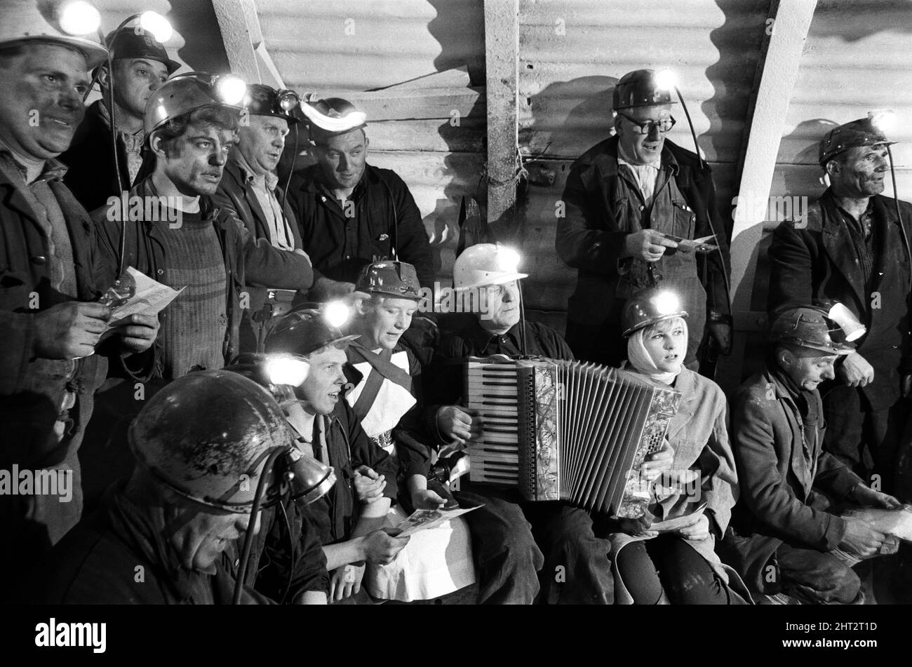 Carol service by miners 600 ft down. An accordion play and miners voices are raised in the singing of Christmas Carols. Wath Main Colliery, near Mexborough, South Yorkshire. 23rd December 1966. Stock Photo