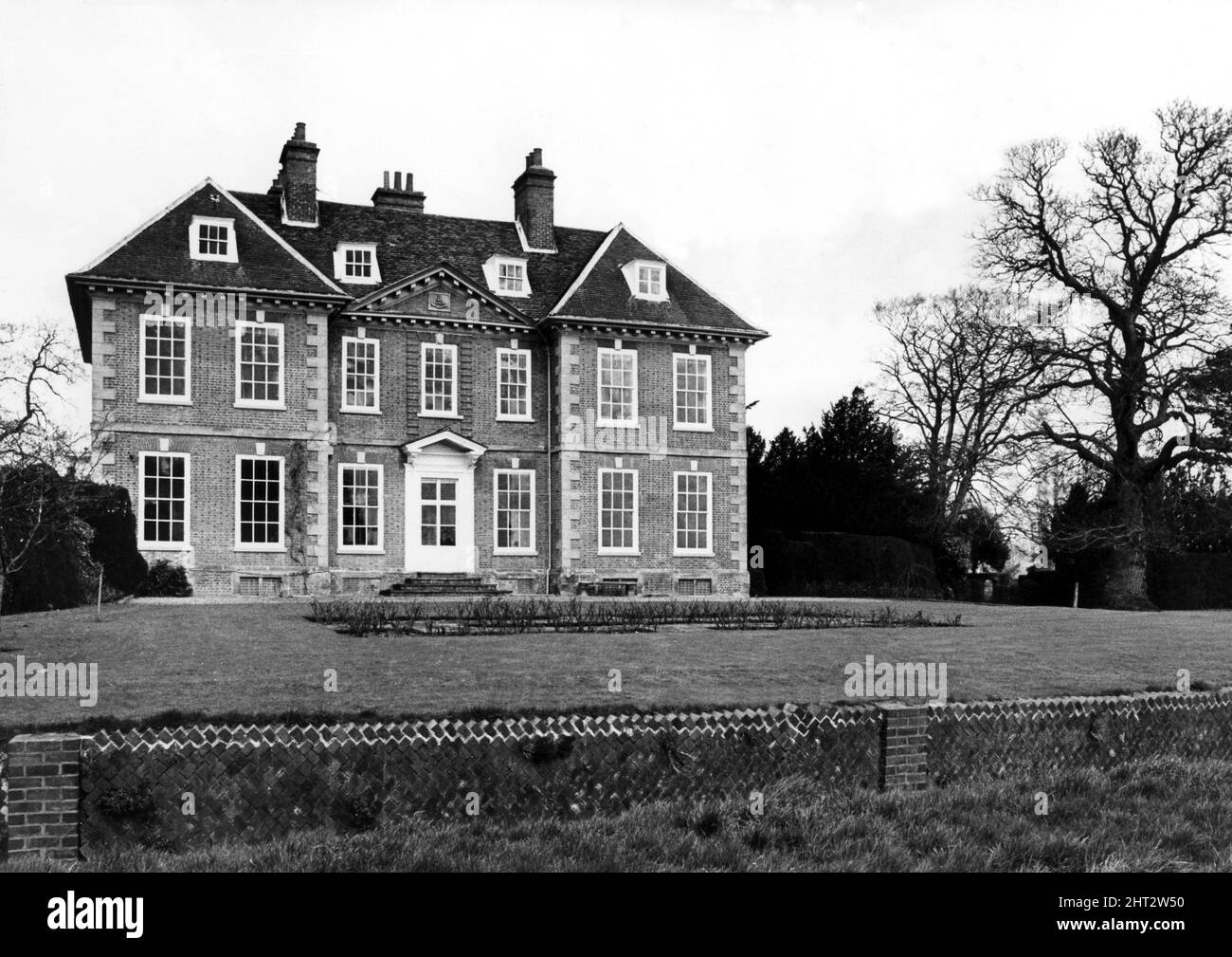Alveston House in Alveston village near Stratford. It was sold in 1810 for ﾣ39,500 which ended a family  connection with peaceful Alveston which had lasted since 16th century days.  It has been described by a very great expert as 'a singularly perfect example of the Wren type of country house.'  Beautiful brickwork with dark blue headers and neat angle-dressings of stone, surrounds tall sash windows whose thin, elegant glazing bars replace sturdier ones or possibly mulions and transforms.  There are the expected dormers in the high-pitched roof which displays the typical white - painted modill Stock Photo