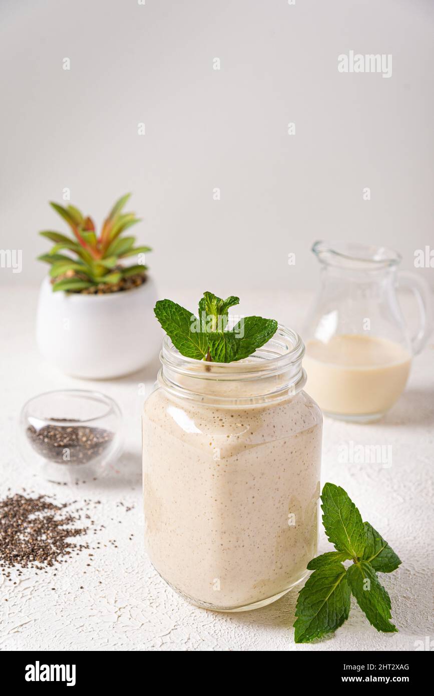 vanilla protein shake glass jar mint. delicious vanilla protein breakfast shake in a mason jar mint leaf Stock Photo