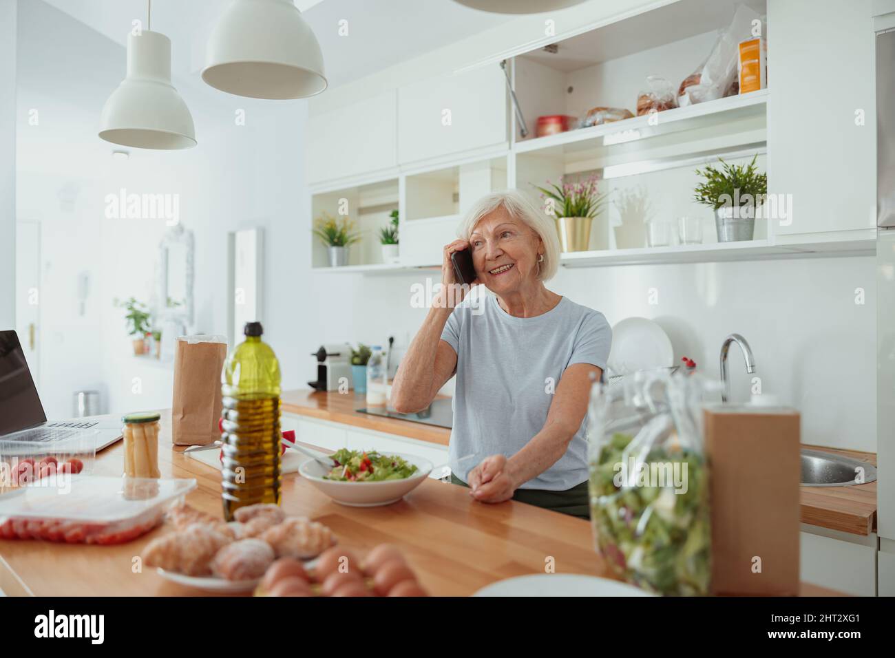 Happy aged female talking on mobile phone indoors Stock Photo - Alamy