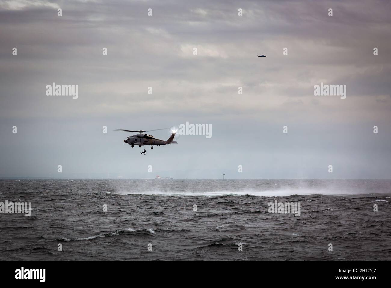 US Navy MH-60 helicopters with rescue swimmers practice off the coast near Yokosuka, Japan. Stock Photo