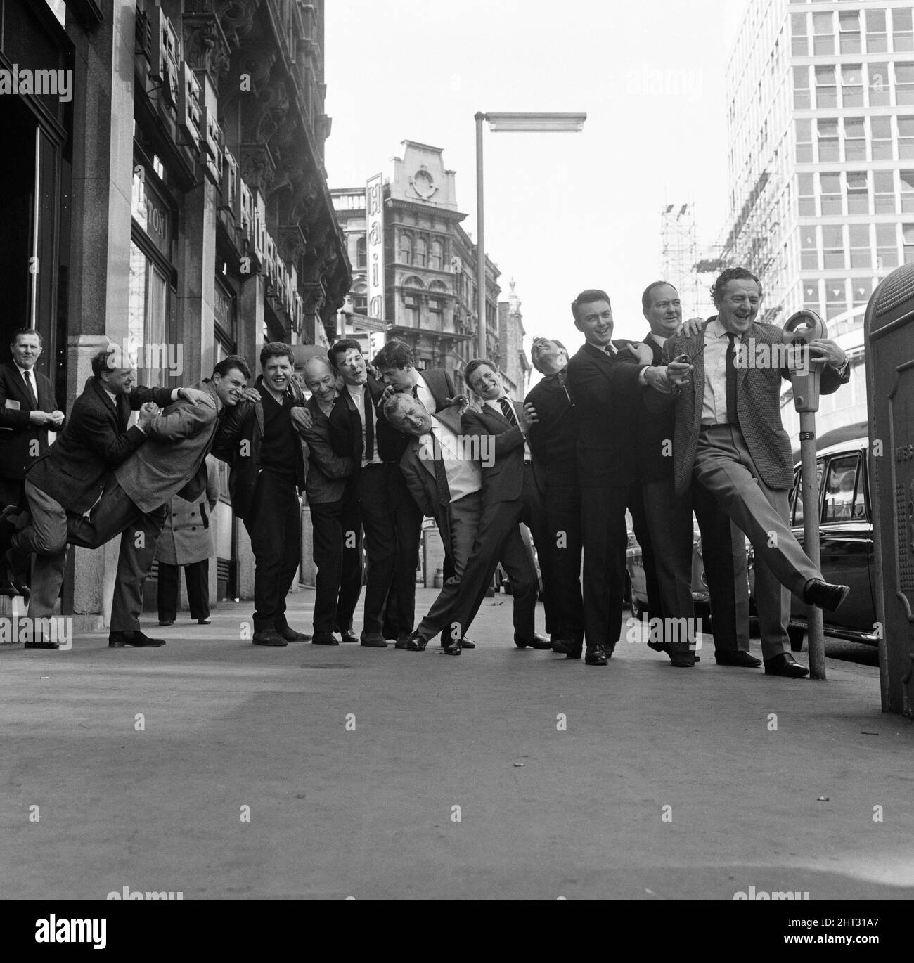 What a sight for TV crime series fans. Here pictured during a break in rehearsals for tonight's show at London's Prince of Wales Theatre are a team of TV cops. Putting the policeman's lock on each other are Z-Cars Inspector Barlow (Stratford Johns) with his colleagues Robert Keegan, James Brady, Brian Blessed, Frank Windsor, James Ellis, Colin Welland, Peter Byrne, Geoffrey Adams, Johnny Briggs, Michael McStay, Robert Raglan, Bruce Seaton and Rupert Davies. 28th March 1965. Stock Photo