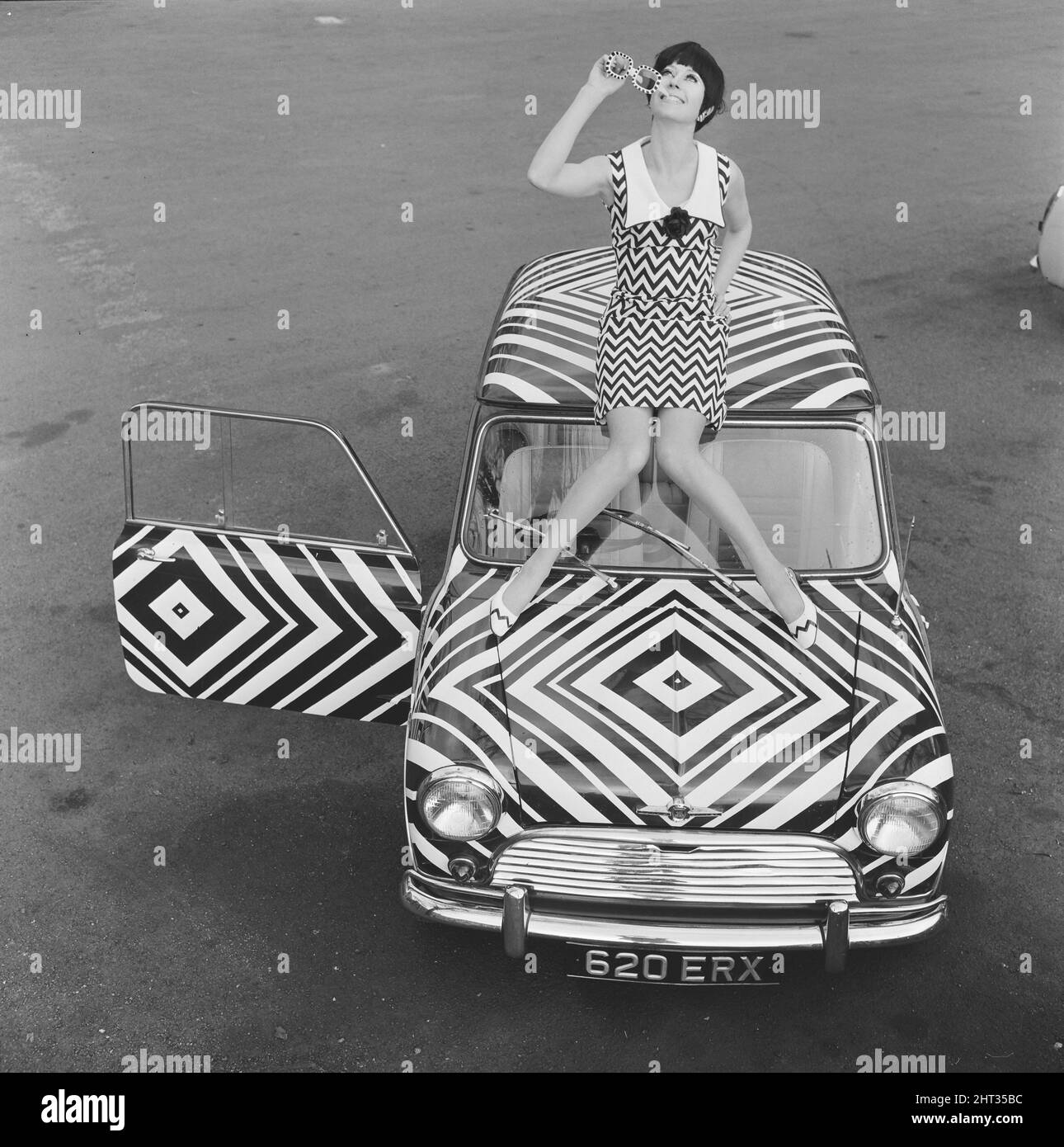 Here it is! The car for the Op Art girl (optical art girl) who likes all her accessories to match, pictured 24th March 1966.   The art was designed & applied by amateur artist Danae Brook, and the car is for sale in Thames Ditton, Surrey; costing £385. But this does not include the cost of the dress, designed by Shubelle & which costs 79 shillings. Stock Photo
