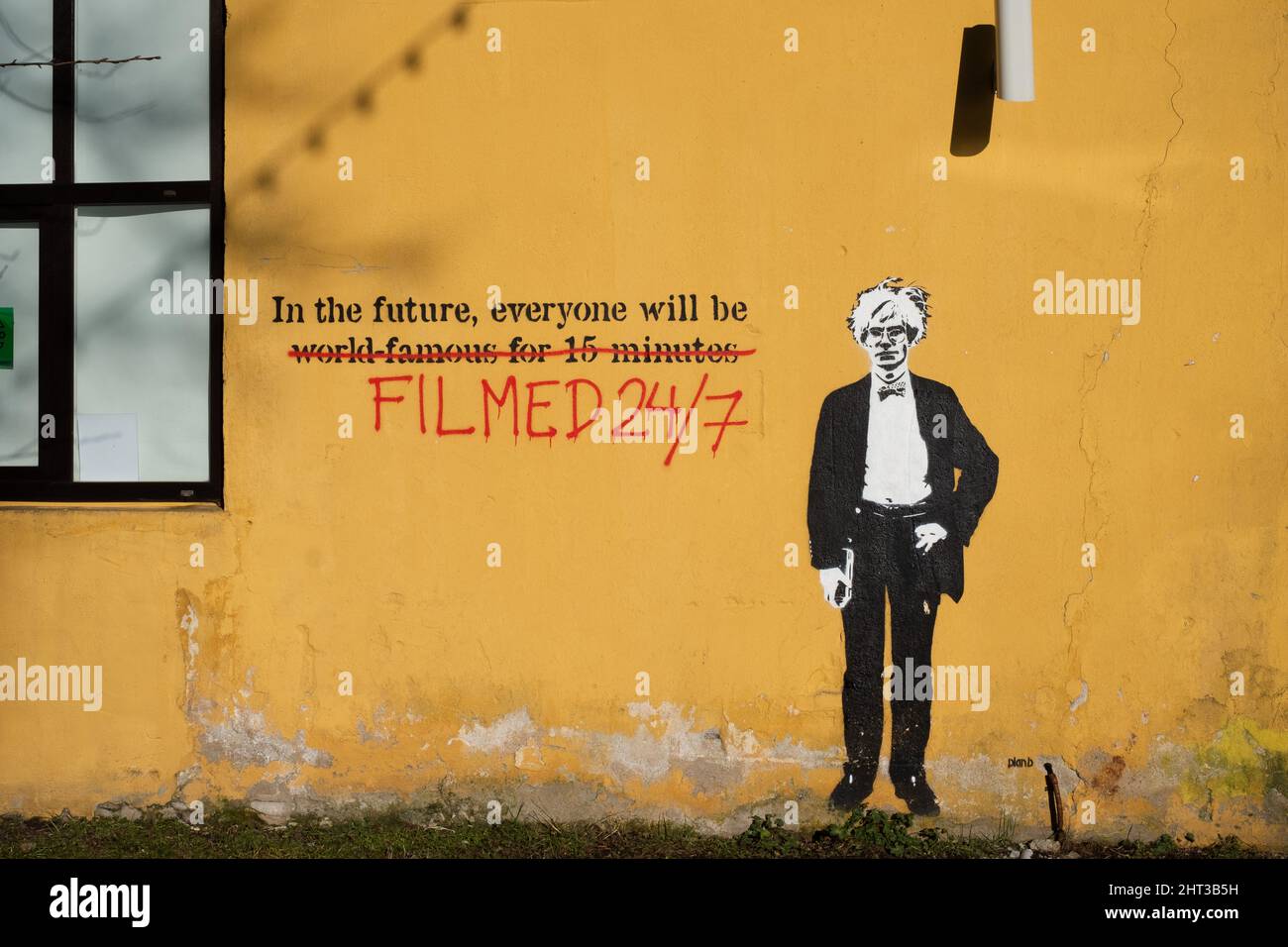 'In the future everyone will be filmed 24/7', crossed out 'world-famous for 15 minutes'. Futuristic street art in Tallinn by Plan B. Stock Photo